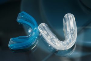 Pre-orthodontic dental trainer alignment appliance on glass background, closeup