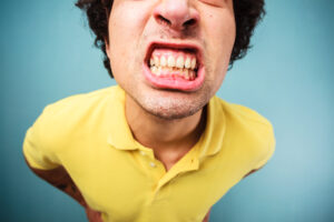 Young man is grinding his teeth and looking angry