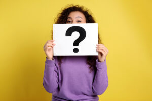 African-American woman with question mark sign on yellow background