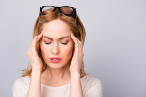 Business woman tired at work suffering from headache